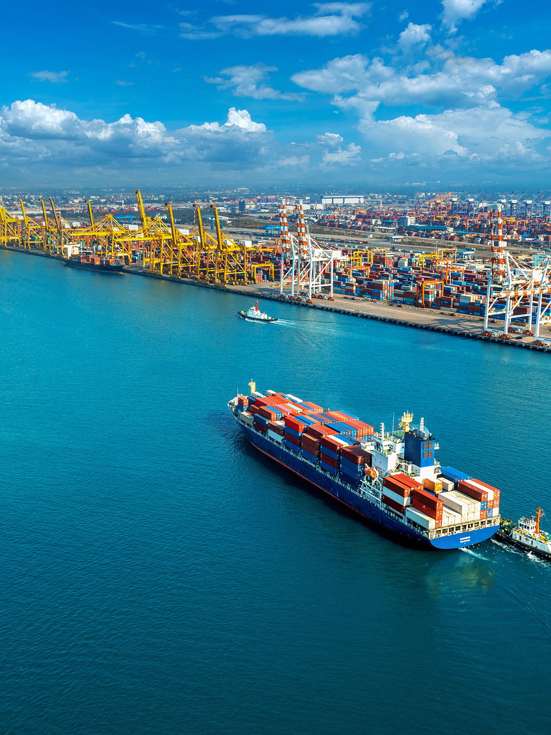 Aerial view of cargo ship and cargo container in harbor.